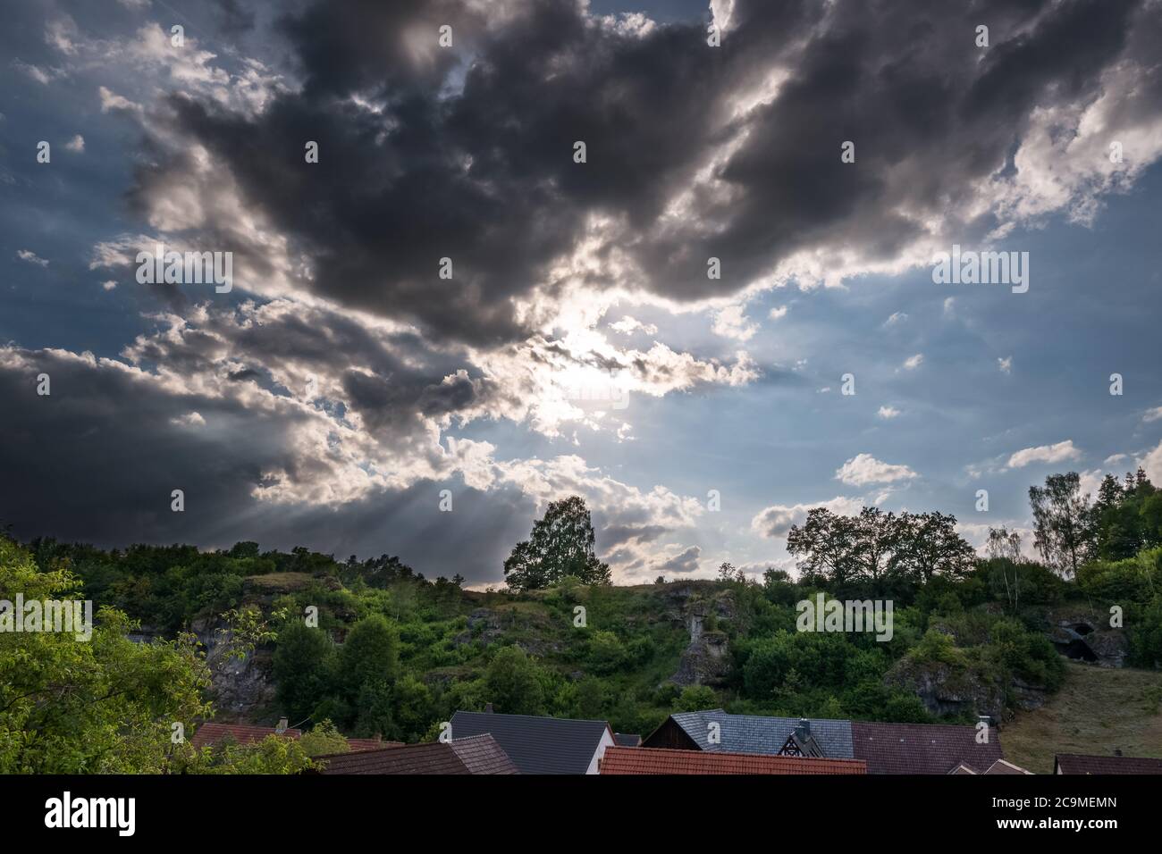 Cielo drammatico sopra il villaggio in Franconia Svizzera nella soleggiata giornata estiva Foto Stock
