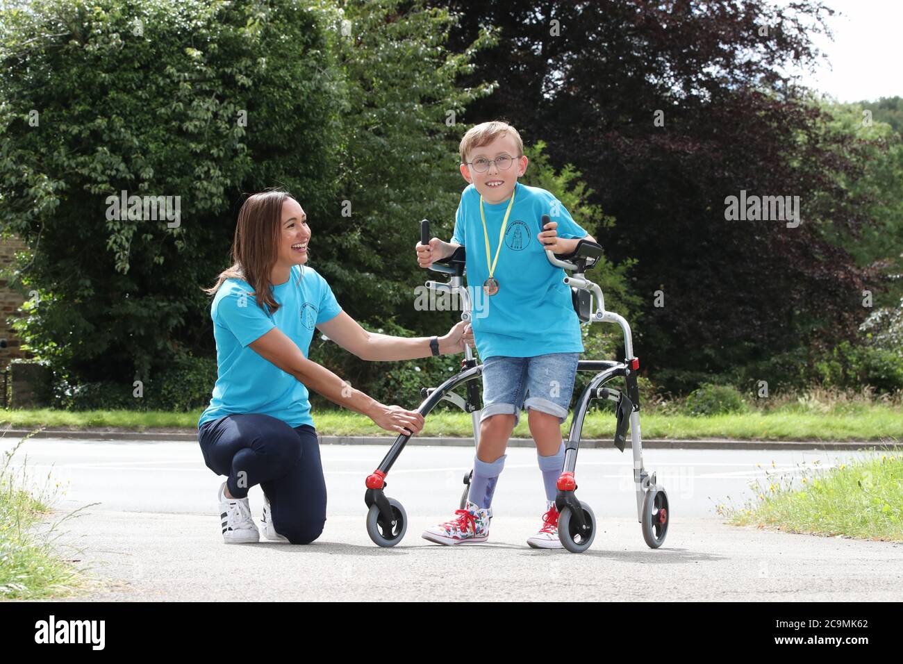 Tobias Weller, che ha paralisi cerebrale e autismo, insieme all'atleta olimpico Jessica Ennis-Hill (a sinistra), ha completato la sua nuova sfida di correre una maratona in strada fuori casa a Sheffield, utilizzando un corridore di gara. Tobias, che non può stare in piedi o camminare senza aiuto, è stato ispirato dal Capitano Tom Moore a completare la sua prima maratona nelle sue passeggiate giornaliere di ritorno in aprile. Foto Stock