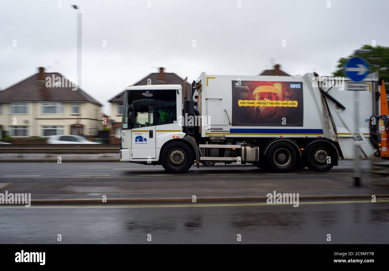 Un lavoratore chiave Southampton città rifiuti camion che mostra un Covid-19 soggiorno a casa proteggere il poster del messaggio di informazioni NHS sul lato. Foto Stock