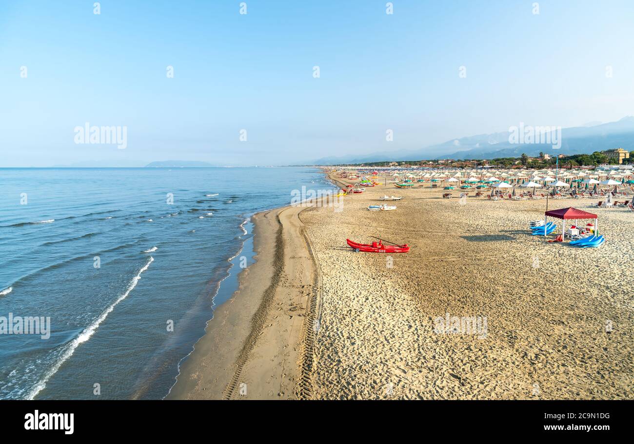 Vista sulla spiaggia di Marina di Pietrasanta con sabbia bianca, ombrelloni  e sedie al mattino presto in Versilia, Toscana, Italia Foto stock - Alamy