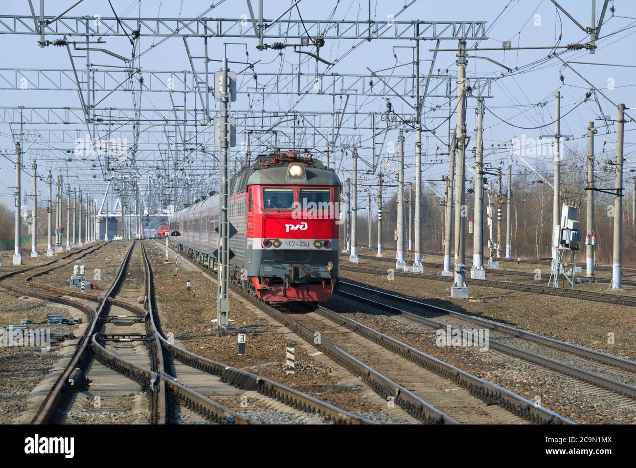 REGIONE DI LENINGRAD, RUSSIA - 05 MARZO 2018: Una locomotiva elettrica a due sezioni della ChS7 con il treno passeggeri sulle rotaie nella primavera del pomeriggio Foto Stock