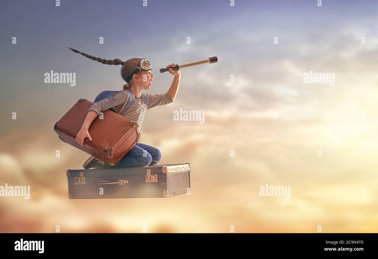 Sogni di viaggio! Bambino che vola su una valigia sullo sfondo del tramonto  Foto stock - Alamy