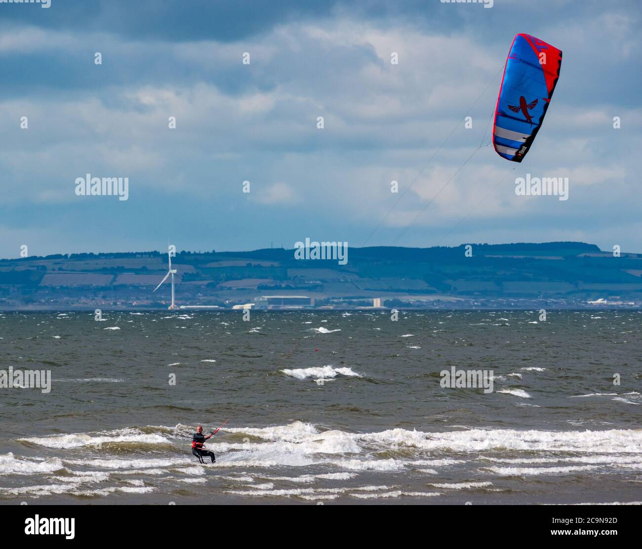 Kite surfer kite boarding in giornata ventosa con kite colorato, Firth of Forth, Scozia, Regno Unito Foto Stock