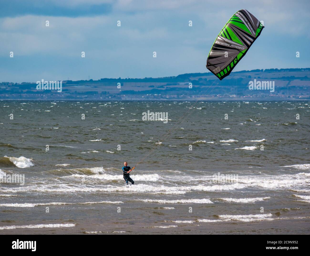 Kite surfer kite boarding in giornata ventosa con kite colorato, Firth of Forth, Scozia, Regno Unito Foto Stock