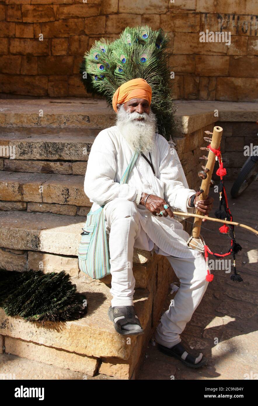 Città vecchia di Jaisalmer, vita quotidiana del popolo indiano. Vecchio uomo che vende piume di pavone. Feb 2013 Rajasthan, India Foto Stock