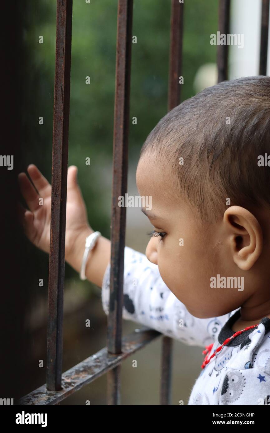 Cute Indian Baby alla finestra durante Corona Foto Stock