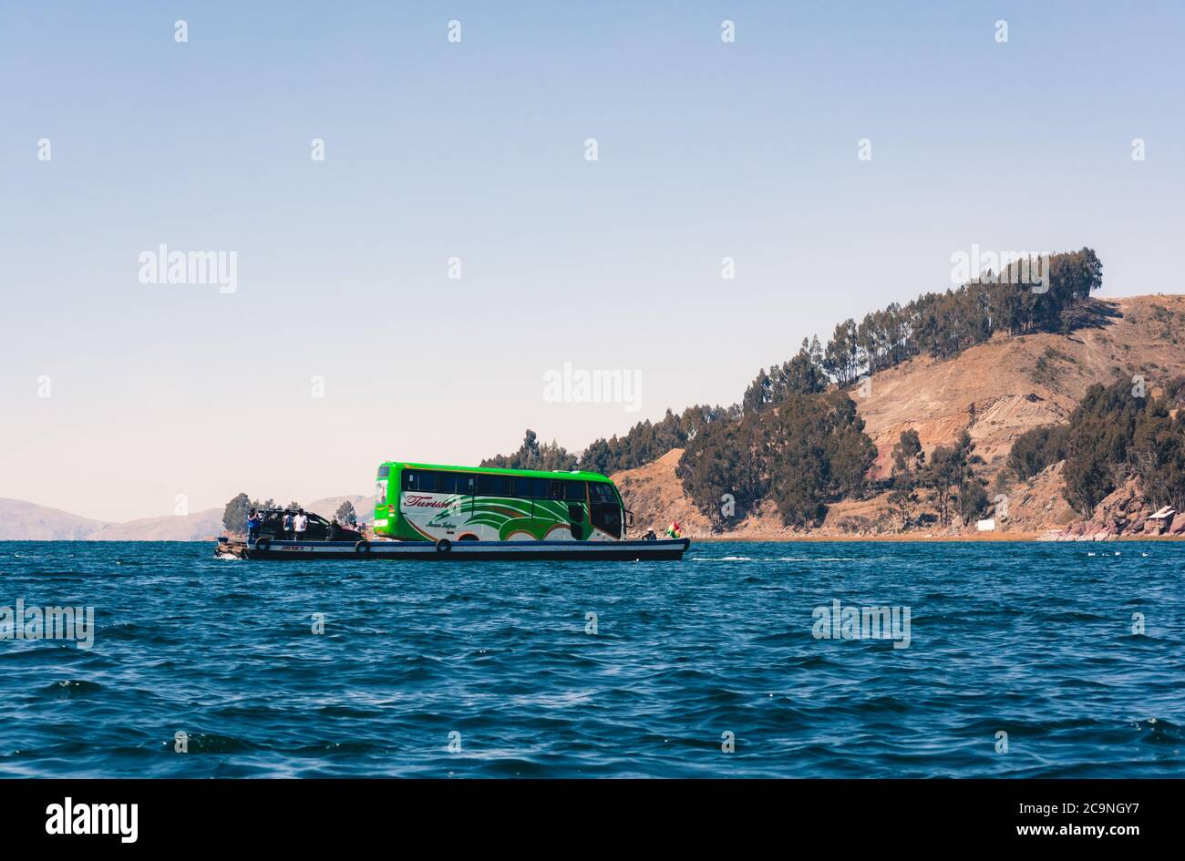 SAN PEDRO DE TIQUINA, BOLIVIA - 23 LUGLIO 2016: Un autobus turistico è trasportato su una zattera di legno nel lago Titicaca, Bolivia Foto Stock