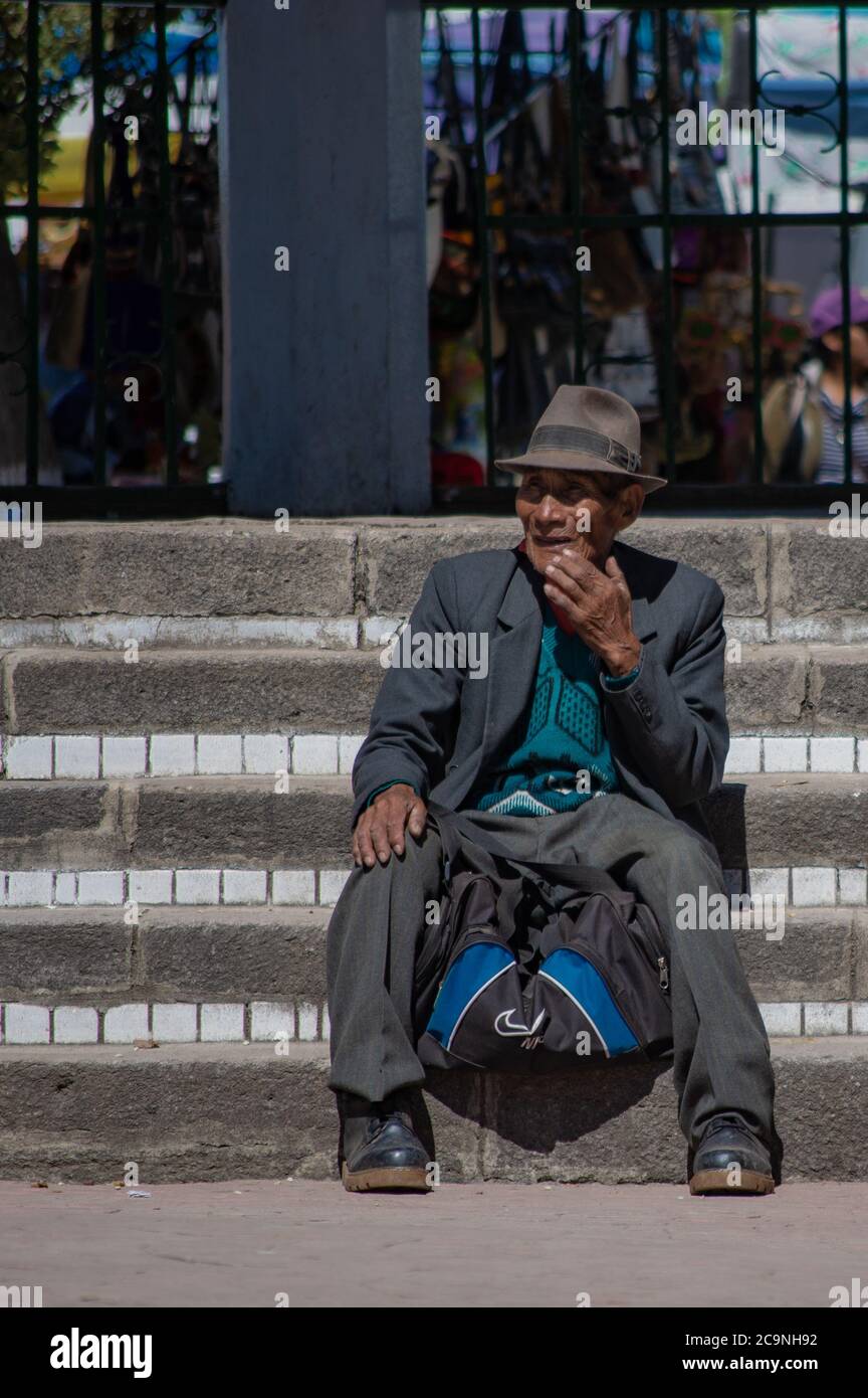 COPACABANA, BOLIVIA - 24 LUGLIO 2016: Vecchio boliviano con cappello si siede sulle scale a Copacabana, Bolivia Foto Stock