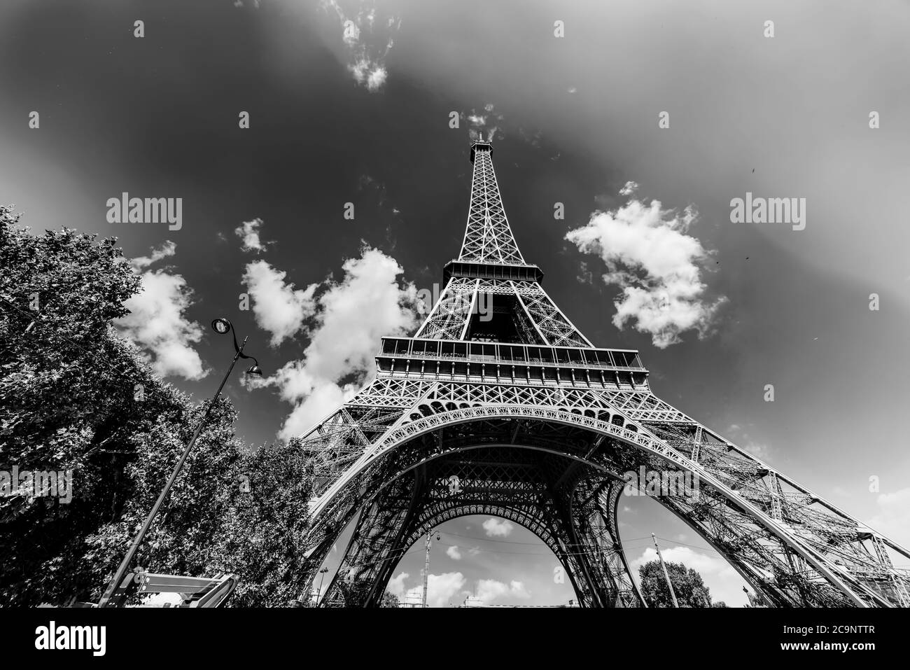 Torre Eiffel famosa in tutto il mondo sotto un cielo blu con le nuvole. Parigi, Francia. Effetto bianco e nero Foto Stock