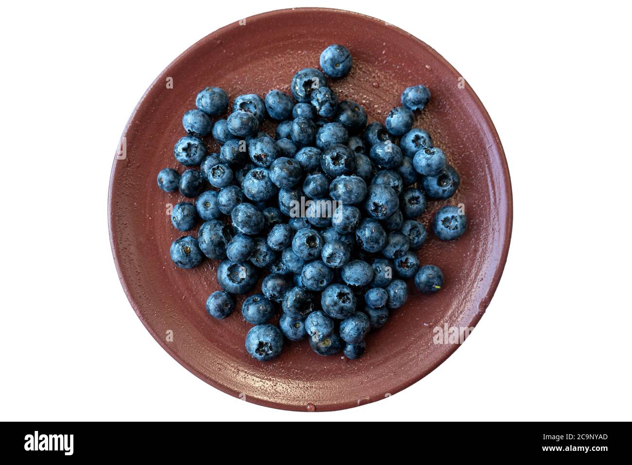 Bacche nere fresche o mirtilli in una piastra di ceramica di argilla marrone fotografata dall'alto. Primo piano di fragole fresche e salutari. Foto Stock