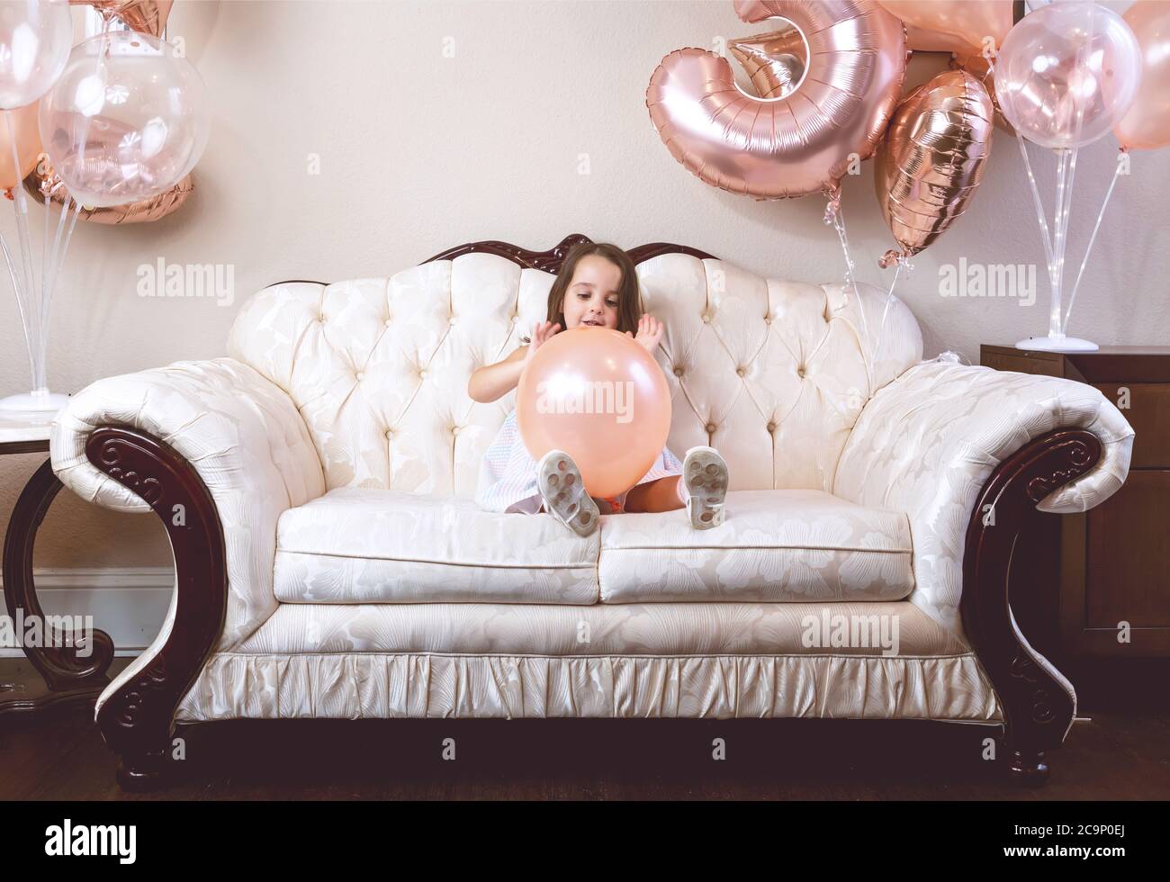 ragazza di compleanno di 3 anni che gioca con i suoi palloncini sul divano  Foto stock - Alamy