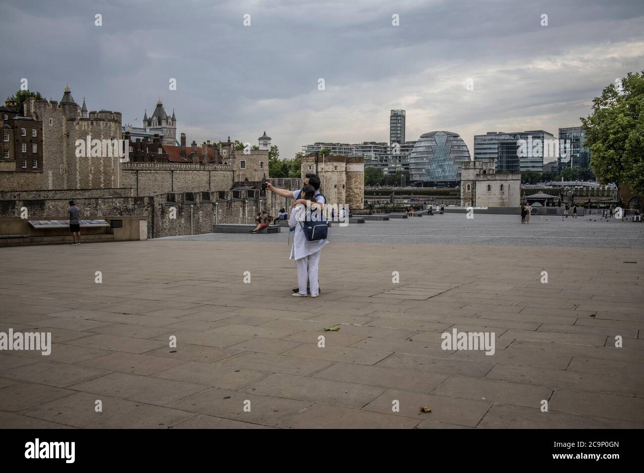 I turisti che si godono il vuoto vicino intorno alla zona turistica solitamente trafficata della Torre di Londra in un venerdì pomeriggio, dopo il blocco del coronavirus, Regno Unito Foto Stock