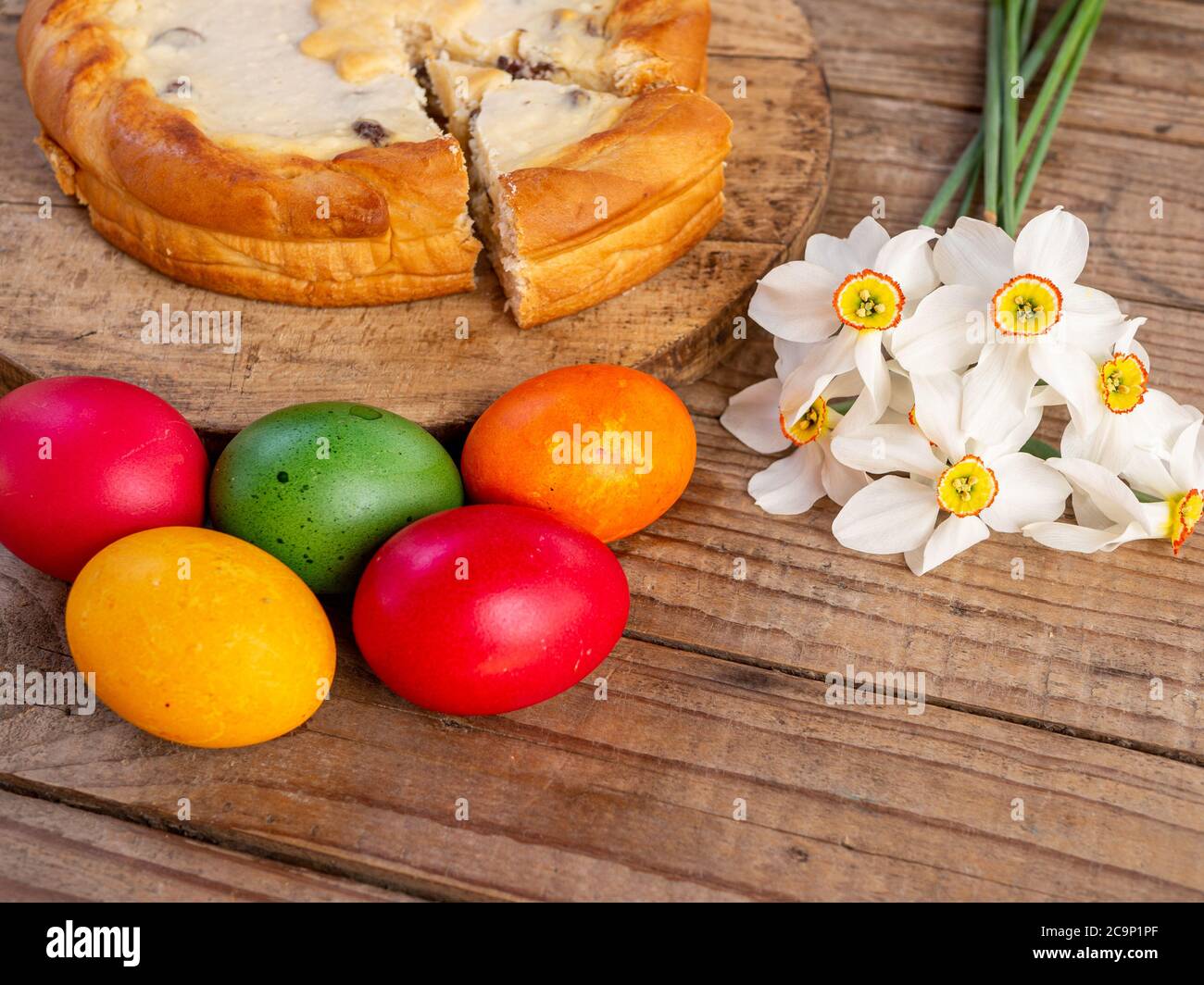 tradizionale rumeno di pasqua cozonac e pasca o dolce pane e torta di formaggio come su tavola di legno e uova di pasqua colorate e fiori Foto Stock