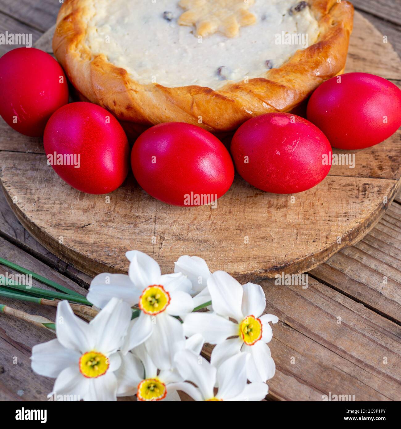tradizionale rumeno di pasqua cozonac e pasca o dolce pane e torta di formaggio come su tavola di legno e uova di pasqua colorate e fiori Foto Stock