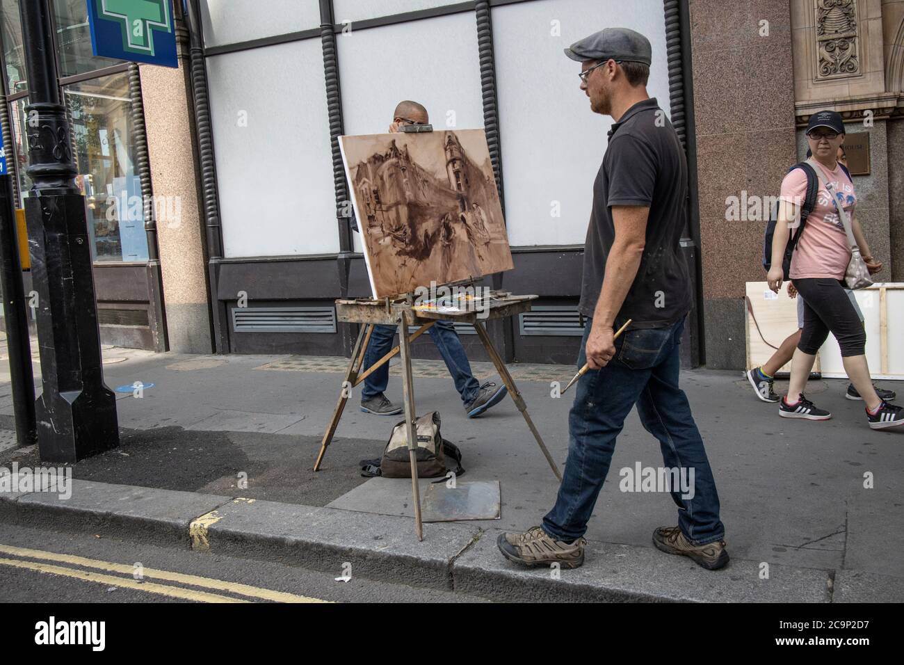 Artista di strada che cattura su tela l'angolo di Wellington Street e Stran, Londra centrale, Inghilterra, Regno Unito Foto Stock