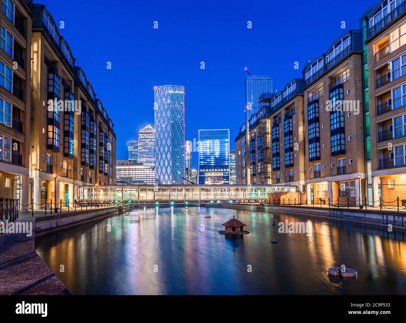 Scena notturna degli edifici finanziari e residenziali di Canary Wharf Case riflesse nel fiume Tamigi Foto Stock