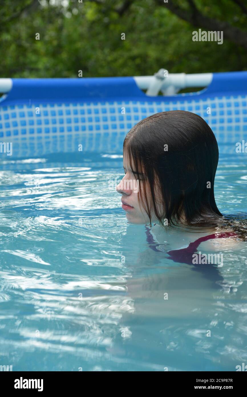 giovane donna che si rilassa in piscina Foto Stock