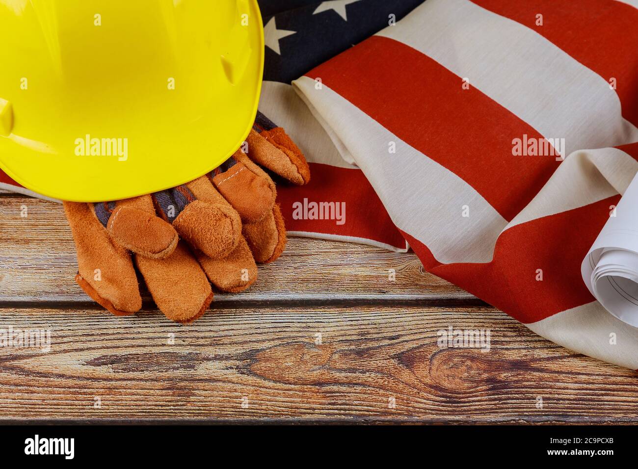 Costruzione casco giallo e guanti in pelle su Happy Labor Day USA una festa federale degli Stati Uniti America bandiera patriottica legno sfondo Foto Stock