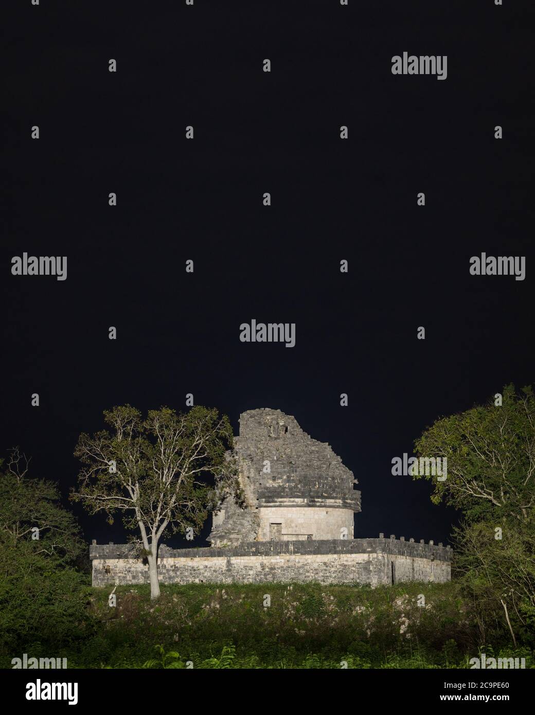 Il Caracol o l'Osservatorio nelle rovine della grande città maya di Chichen Itza, Yucatan, Messico. La rovina è illuminata di notte da un hotel vicino. Foto Stock