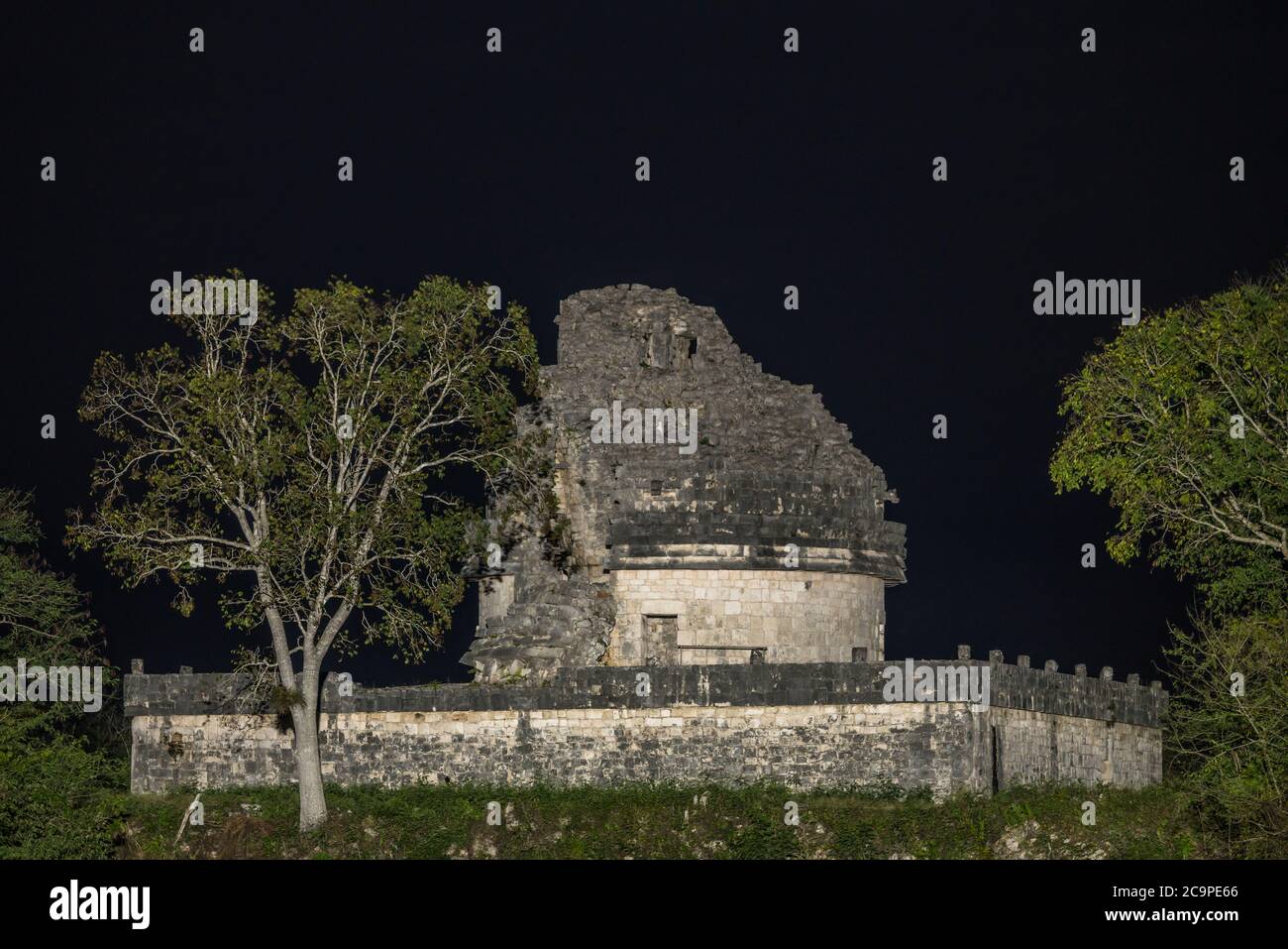 Il Caracol o l'Osservatorio nelle rovine della grande città maya di Chichen Itza, Yucatan, Messico. La rovina è illuminata di notte da un hotel vicino. Foto Stock