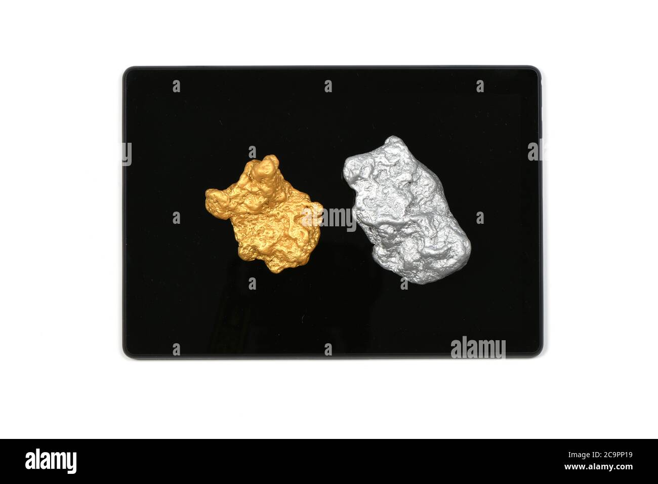 Nocciolo argentato e dorato su tablet pc isolato su sfondo bianco. Foto ad alta risoluzione. Profondità di campo completa. Foto Stock