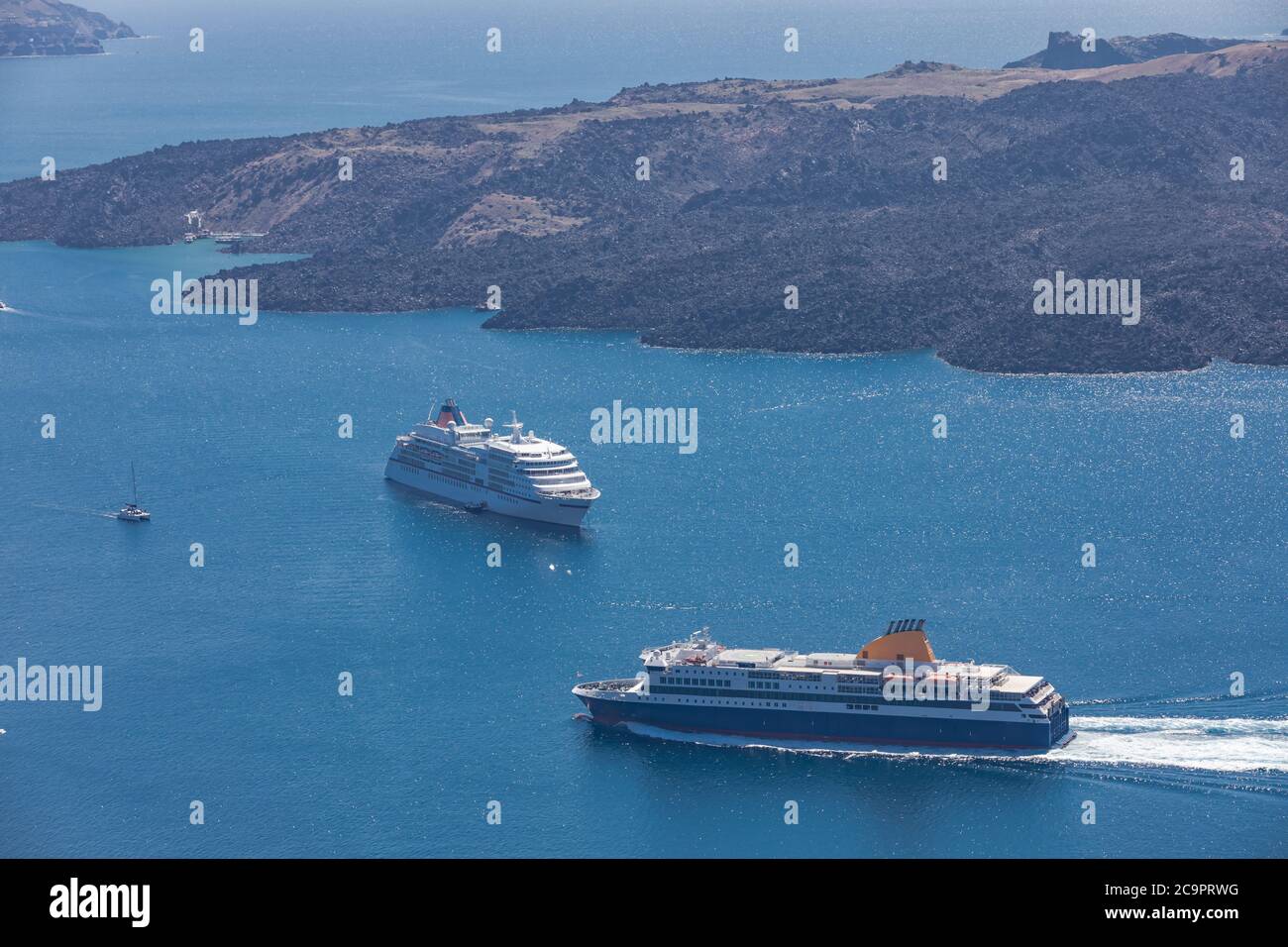 Navi da crociera nei pressi di Santorini. Mare blu profondo con barche turistiche alla luce del sole del mattino Foto Stock