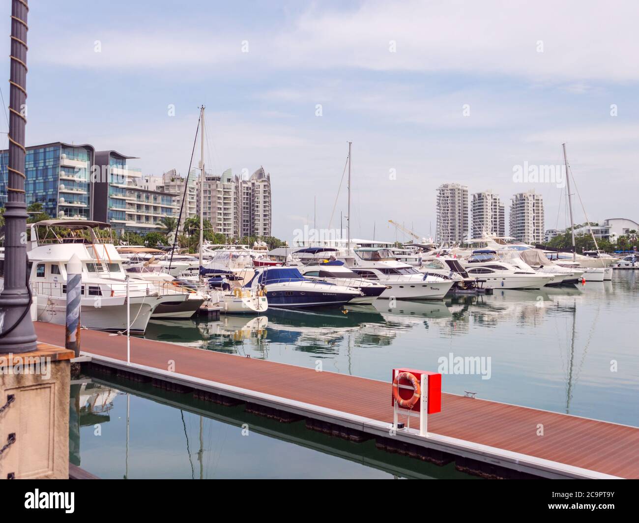 SINGAPORE – 31 LUGLIO 2020 – Barche ricreative di lusso attraccate a Quayside Isle, Sentosa Cove, con condomini di lusso sullo sfondo a Sentosa Isla Foto Stock
