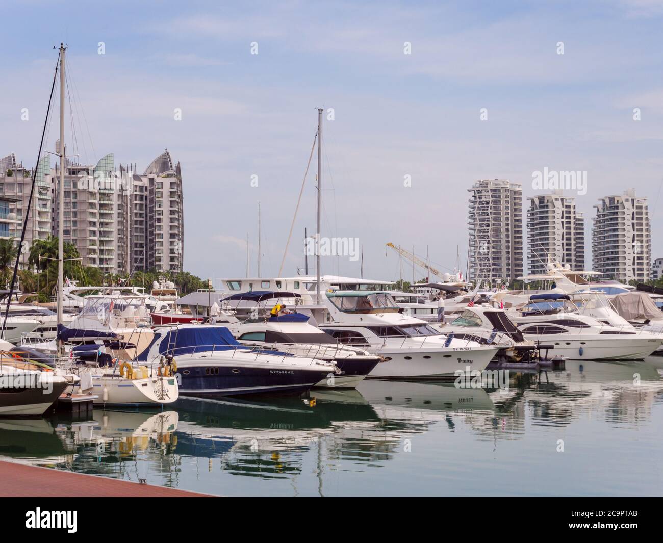 SINGAPORE – 31 LUGLIO 2020 – Barche ricreative di lusso attraccate a Quayside Isle, Sentosa Cove, con condomini di lusso sullo sfondo a Sentosa Isla Foto Stock
