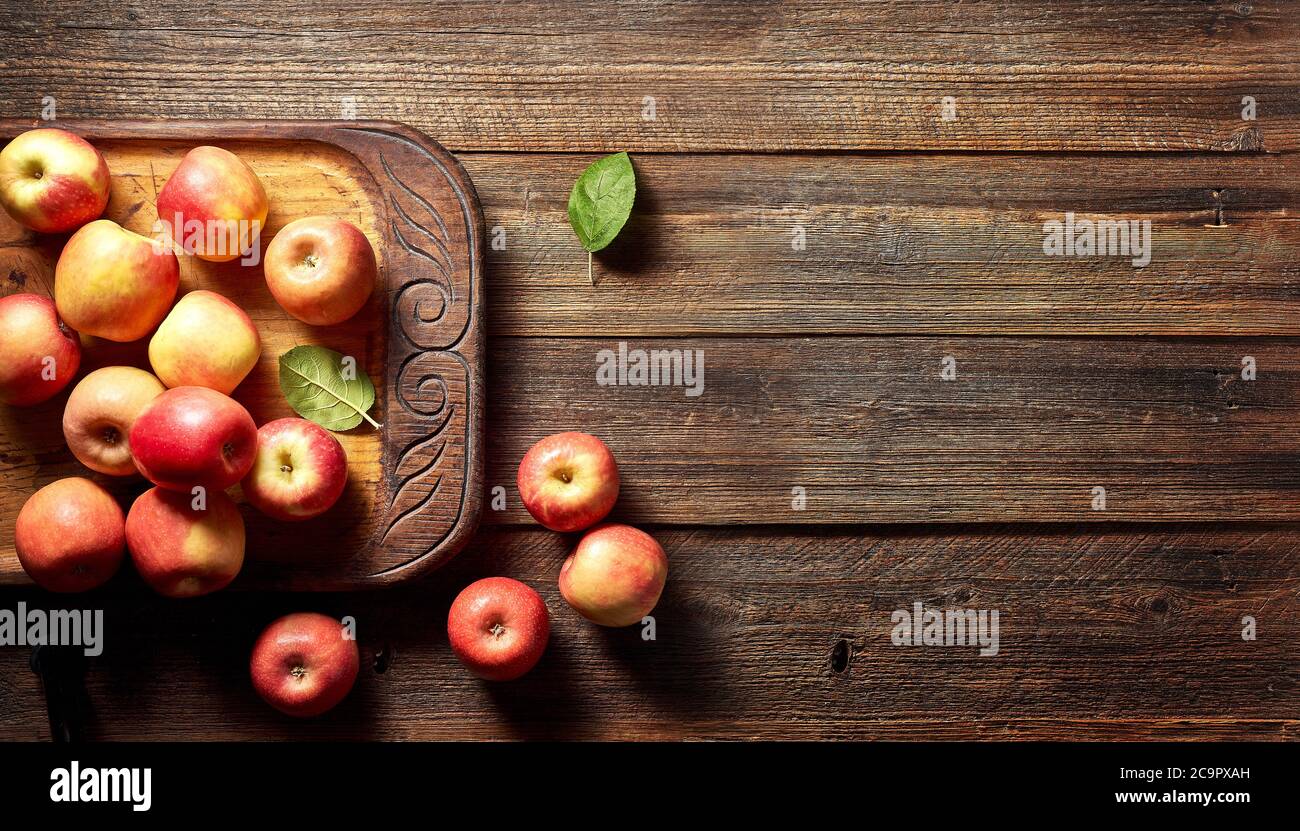Mela rossa e tavola di legno su rustico sfondo di legno con spazio copia. Stagione estiva o autunnale. Foto Stock