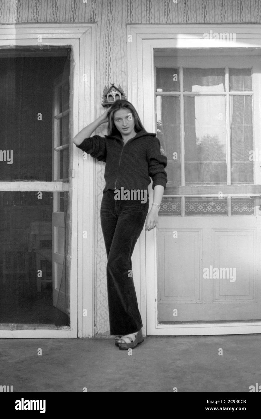 giovane donna che indossa pantaloni svasati in piedi sulla veranda della sua casa ungherese tradizionale anni 60 ungheria Foto Stock