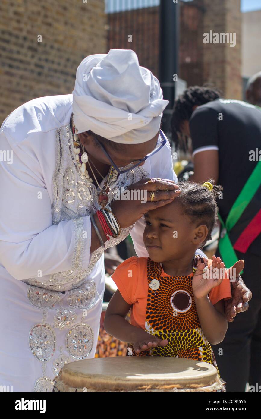 Centinaia di persone si uniscono alla celebrazione del giorno dell'emancipazione di Afrikan a Windrush Square, Brixton. Poiché le strade sono state temporaneamente bloccate fa parte del 'Lockdown Brixton'. Foto Stock