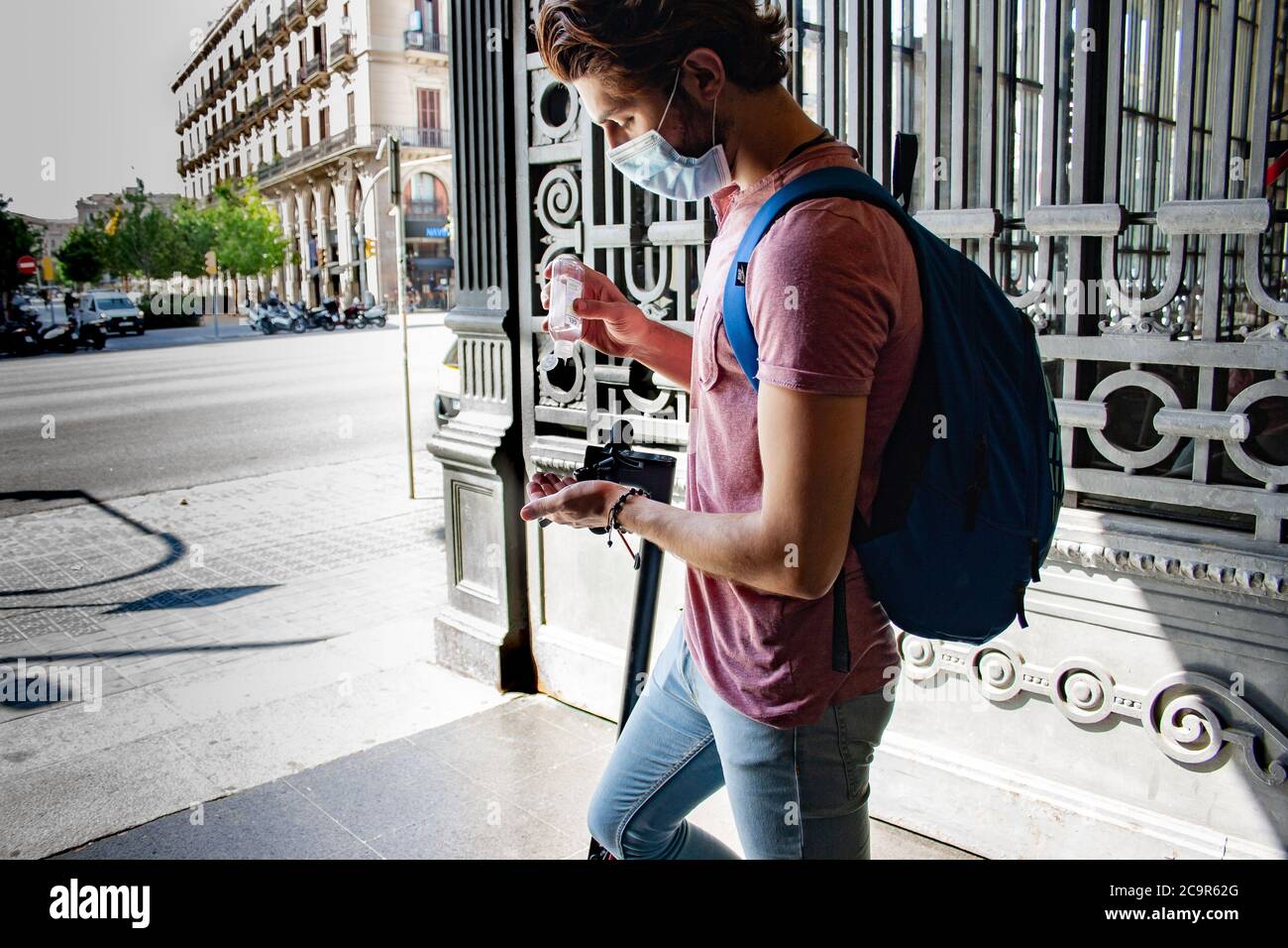 Giovane uomo che versa il gel per le mani prima di lasciare la stazione Foto Stock