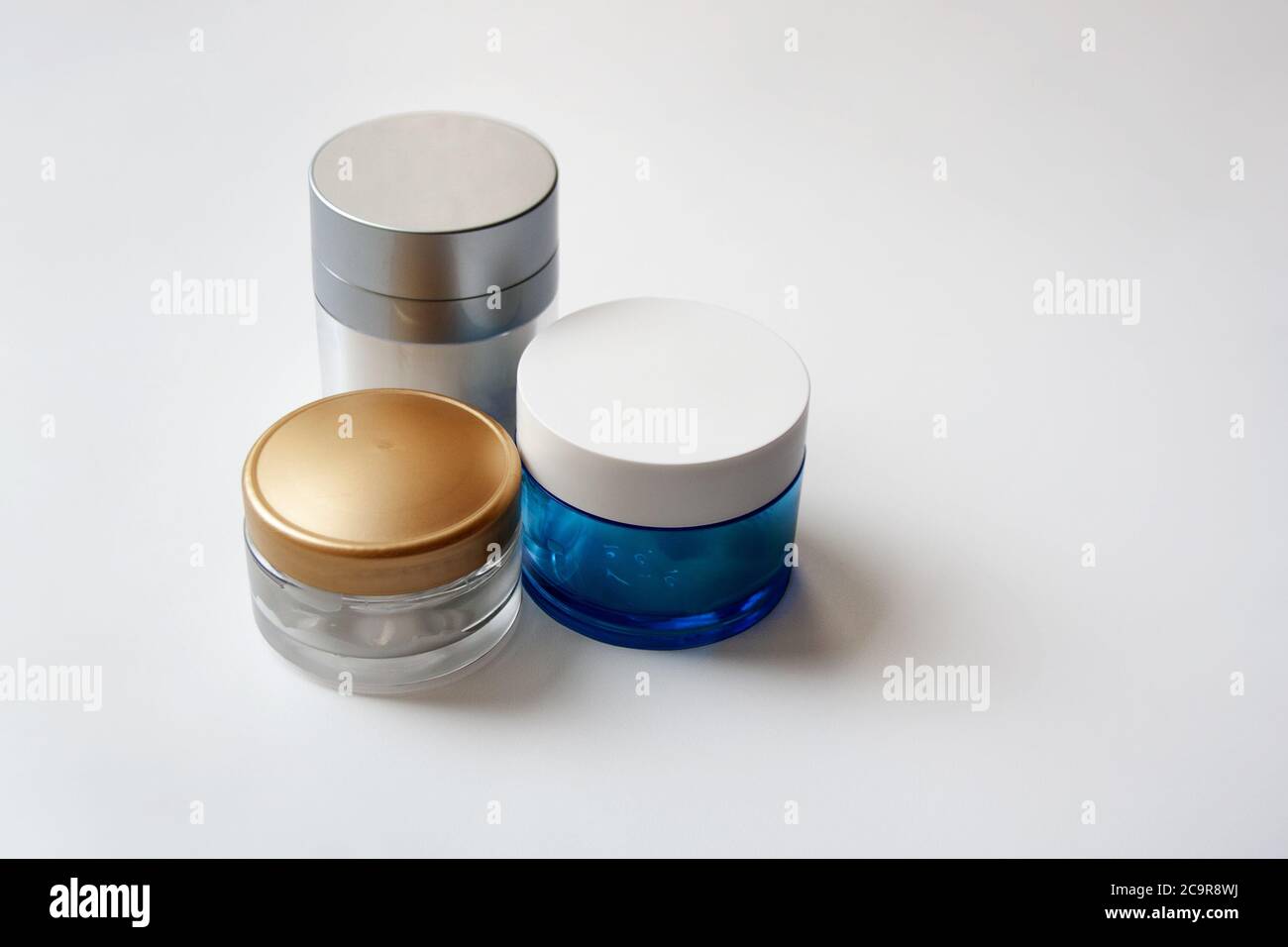 Tre vasetti di vetro cosmetici isolati su sfondo bianco Foto Stock