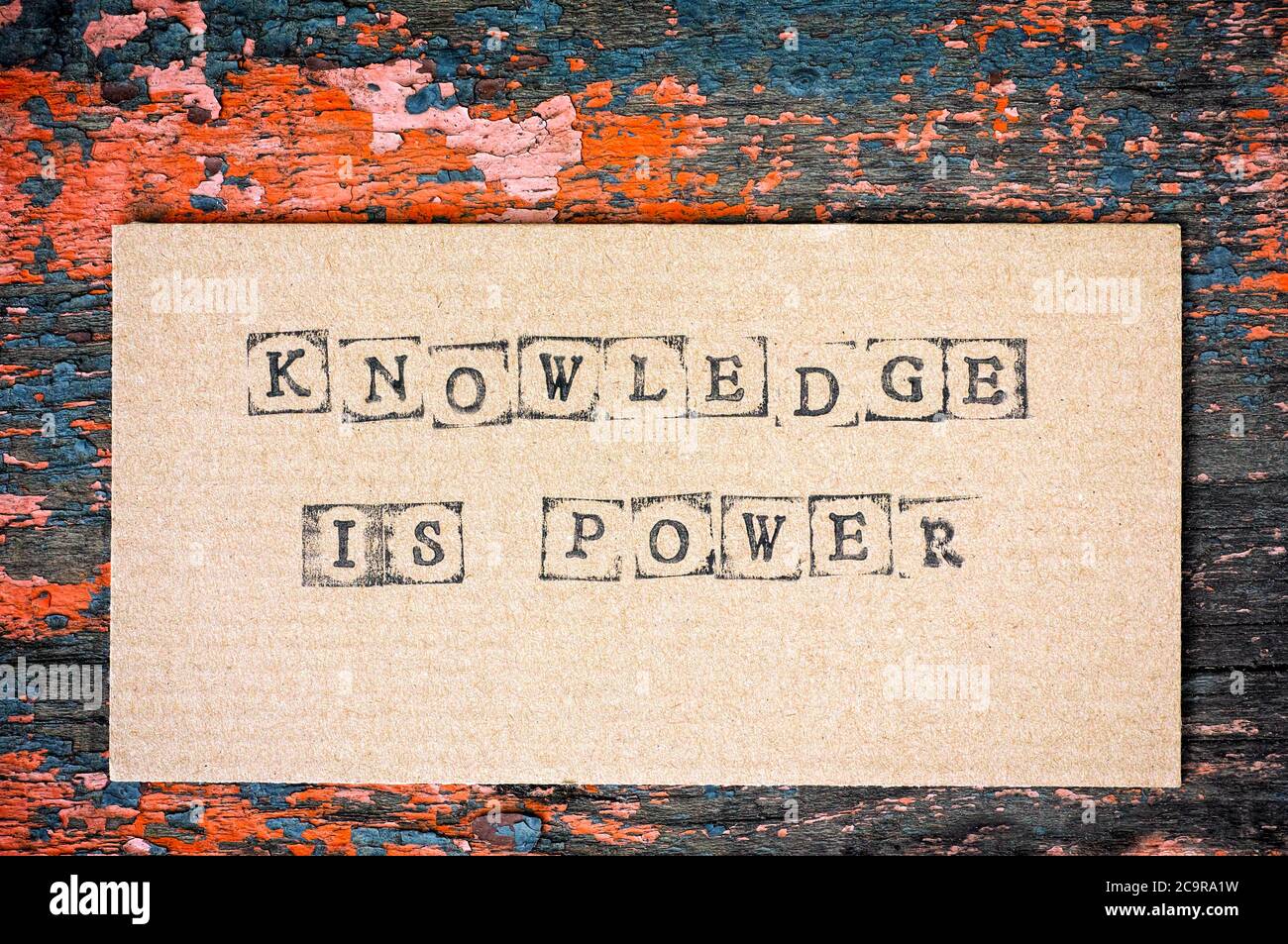 Cartone con parole la conoscenza è l'alimentazione fatta dai timbri dell'alfabeto nero su sfondo di legno. Foto Stock