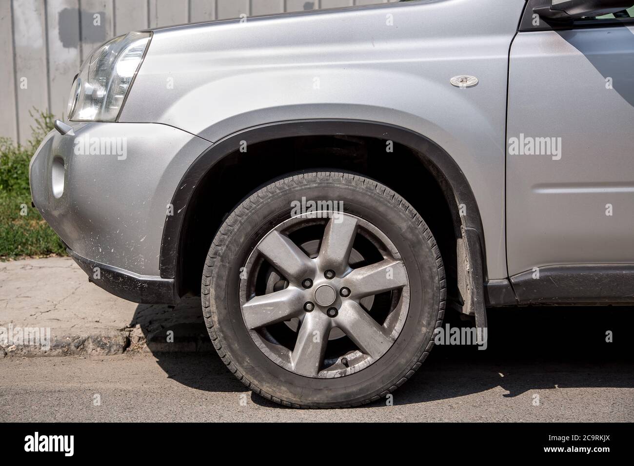 Il colore grigio SUV sporco con il paraurti anteriore e i cerchioni polverosi. Foto Stock