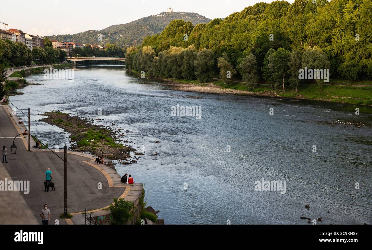 Torino, Piemonte, Italia. Luglio 2020. Splendida vista serale sul fiume po. La gente si rilassa lungo il fiume e il panorama della collina torinese. Foto Stock