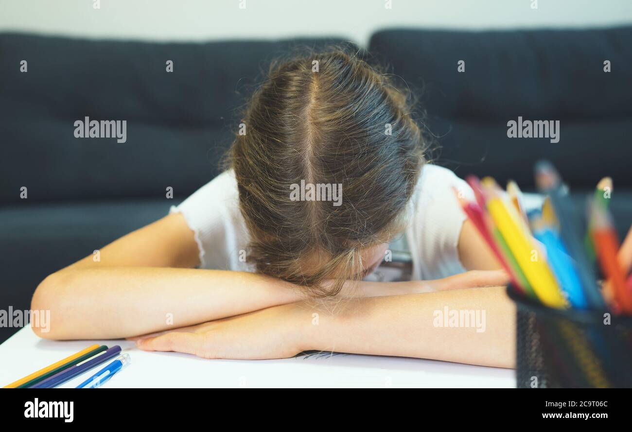Giovane studentessa stanca di disegnare a casa. Foto Stock