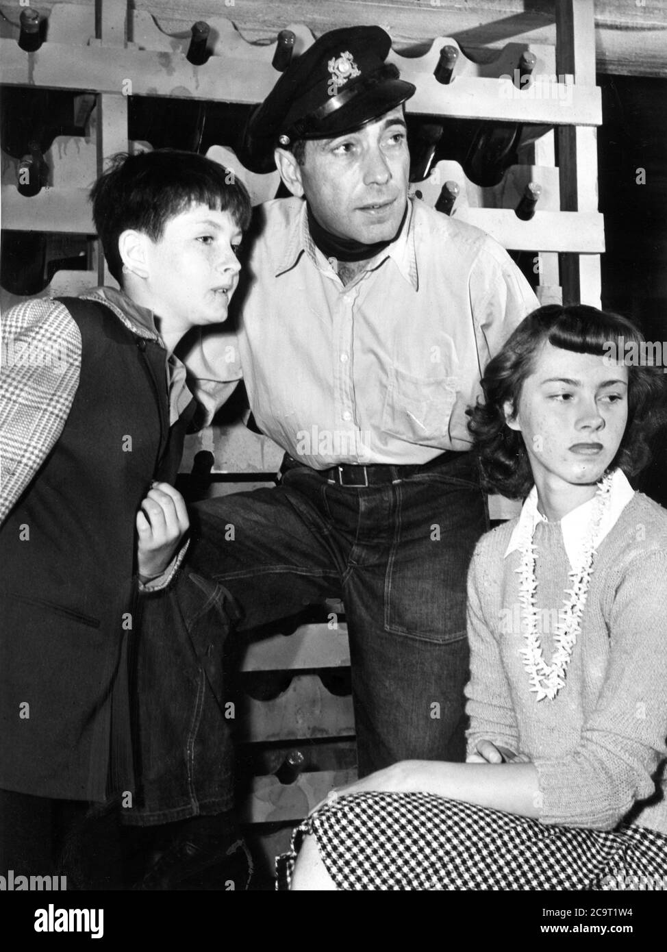 HUMPHREY BOGART ha cantato con i visitatori sul set JOHN BARRYMORE Jr. E DOLORES BARRYMORE (bambini del defunto John Barrymore e sua moglie Dolores Costello) durante le riprese di AVERE E NON HANNO 1944 regista HOWARD HAWKS romanzo Ernest HEMINGWAY sceneggiatura JULES FURTHMAN e WILLIAM FAULKNER Warner Bros Foto Stock