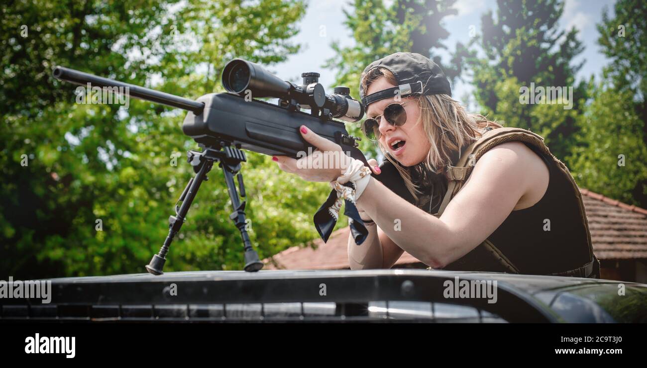 Soldato femmina che spara con fucile da cecchino. Donna con arma. Armi da fuoco esercito tiro e allenamento tattico. Campo di ripresa all'aperto Foto Stock