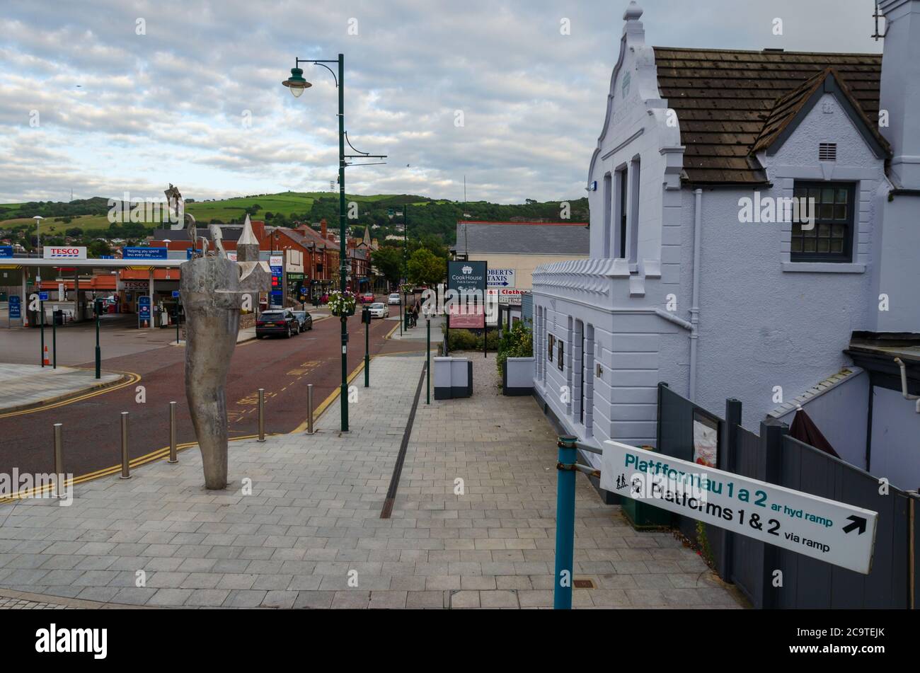 Prestatyn, Regno Unito: 6 giugno 2020: Una scena che mostra la vista che accoglie i passeggeri dal ponte pedonale alla stazione ferroviaria di Prestatyn. La Cookhouse pu Foto Stock