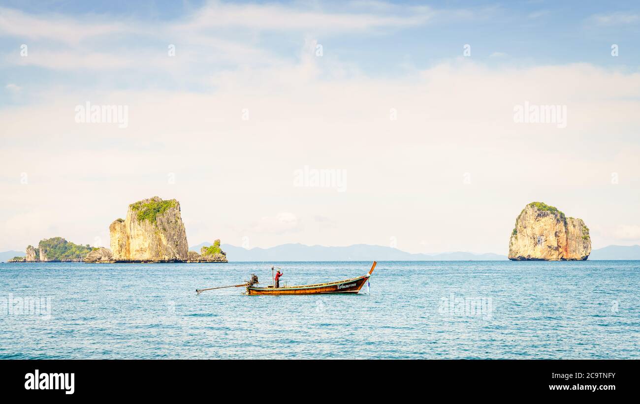Krabi, Thailandia, 9 novembre 2017: Peschereccio tailandese a coda lunga nel Mare delle Andamane con le isole e la costa di Krabi all'orizzonte Foto Stock