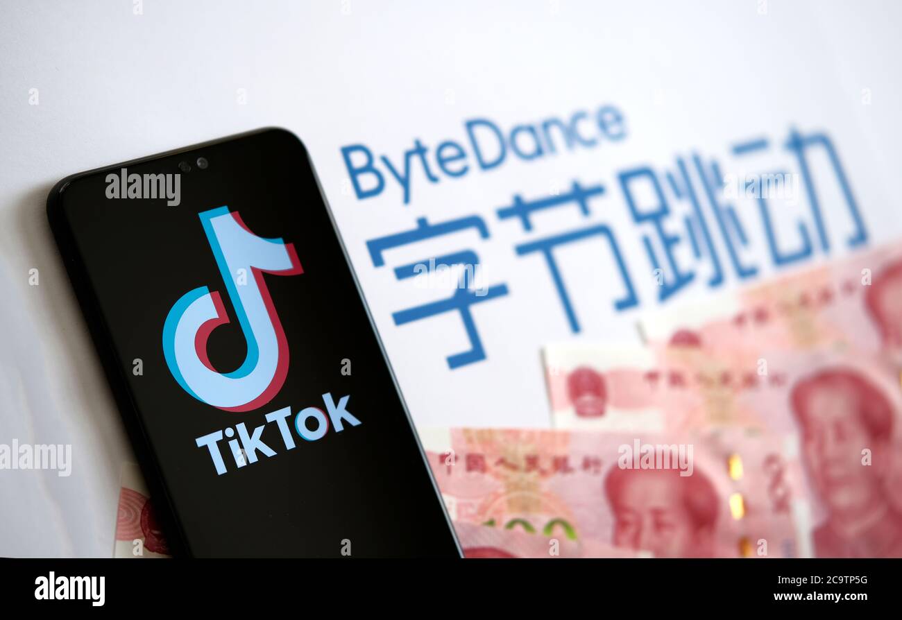 Stone / UK - 2 agosto 2020: Logo dell'app TikTok sullo schermo e logo della società ByteDance con denaro cinese sullo sfondo sfocato. Messa a fuoco selettiva. Foto Stock