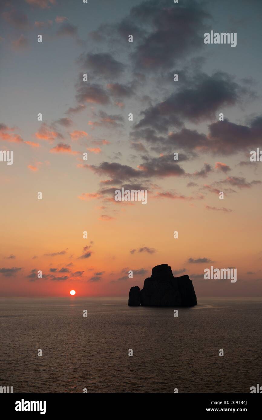 I tramonti dietro il faraglione della pagnotta di zucchero, una formazione calcarea nel sud della Sardegna Foto Stock