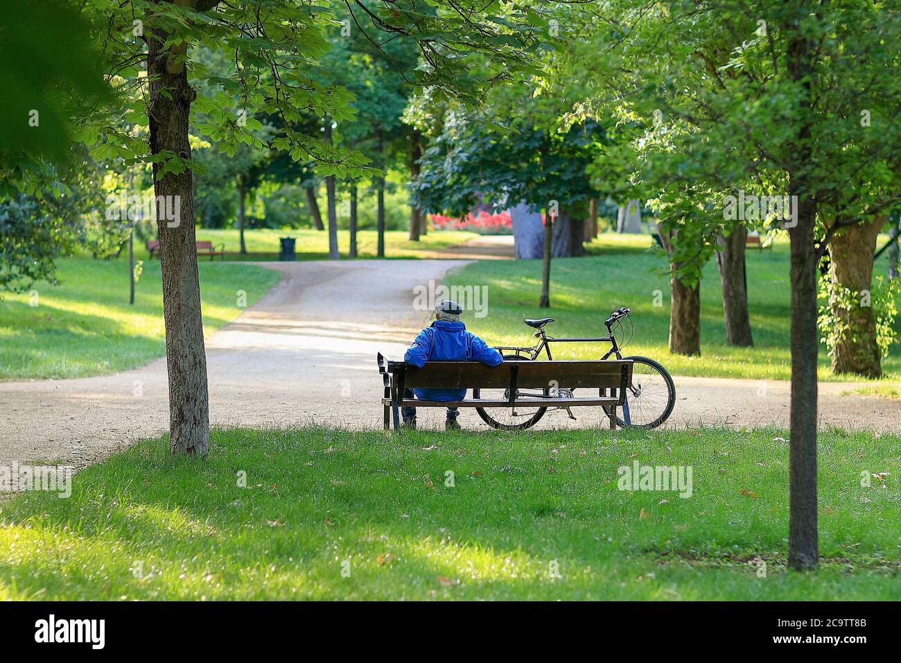 Madrid, Spagna - 31 maggio 2020: Anziano seduto su una panchina accanto alla sua bicicletta in un parco a Madrid. Foto Stock