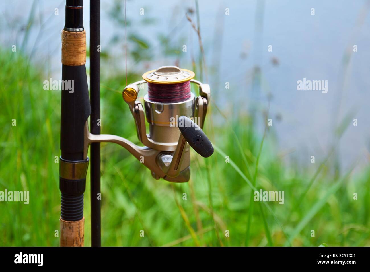 Alimentatore canna da pesca con bobina sul cavalletto contro lo sfondo del  fiume e l'erba. Alimentatore di pesca in stile inglese. Il concetto di fuga  rurale Foto stock - Alamy