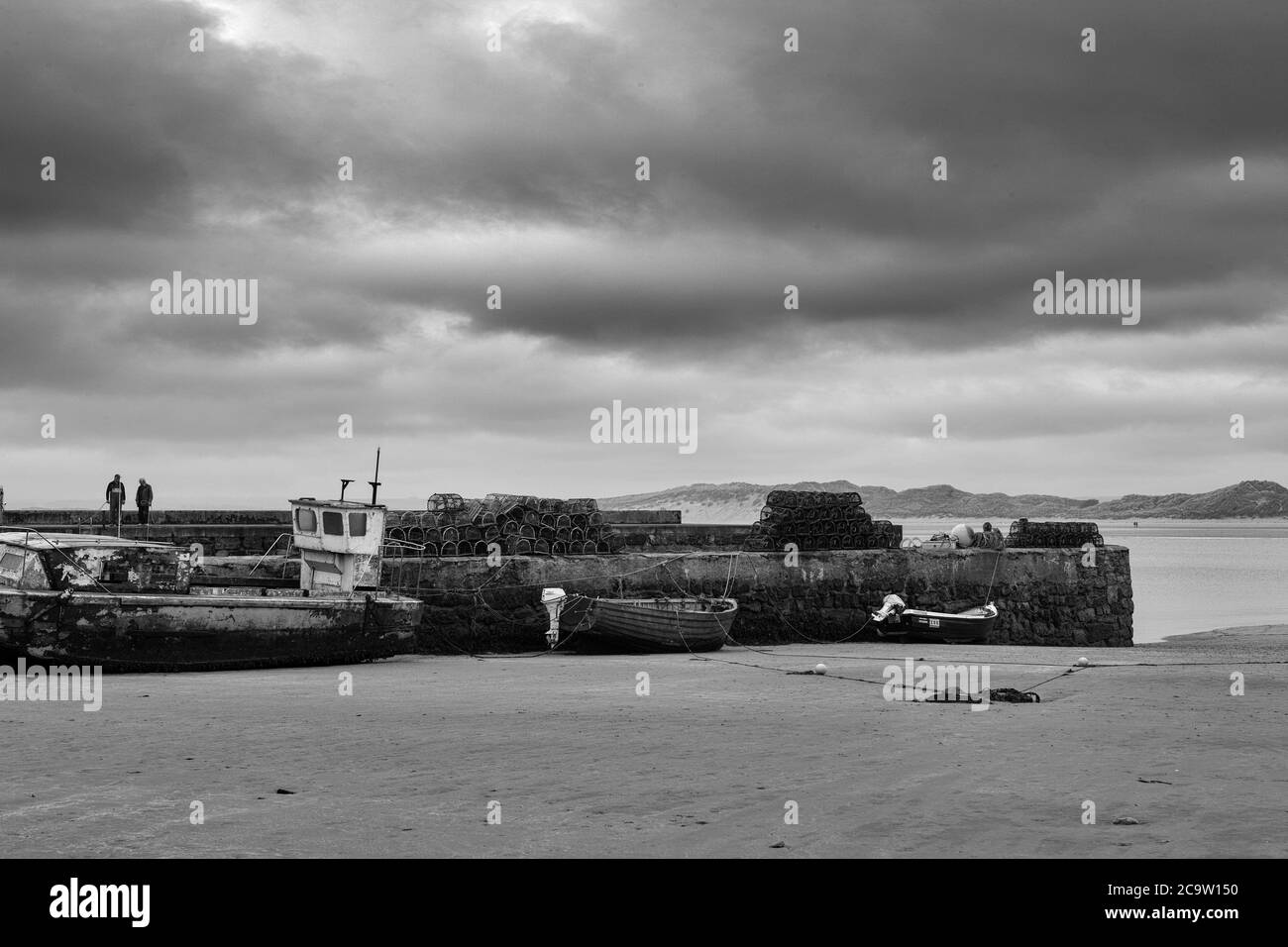 Beadnell Harbor, Northumberland, Inghilterra, Regno Unito: giorno oscuro e bassa marea. Versione in bianco e nero Foto Stock