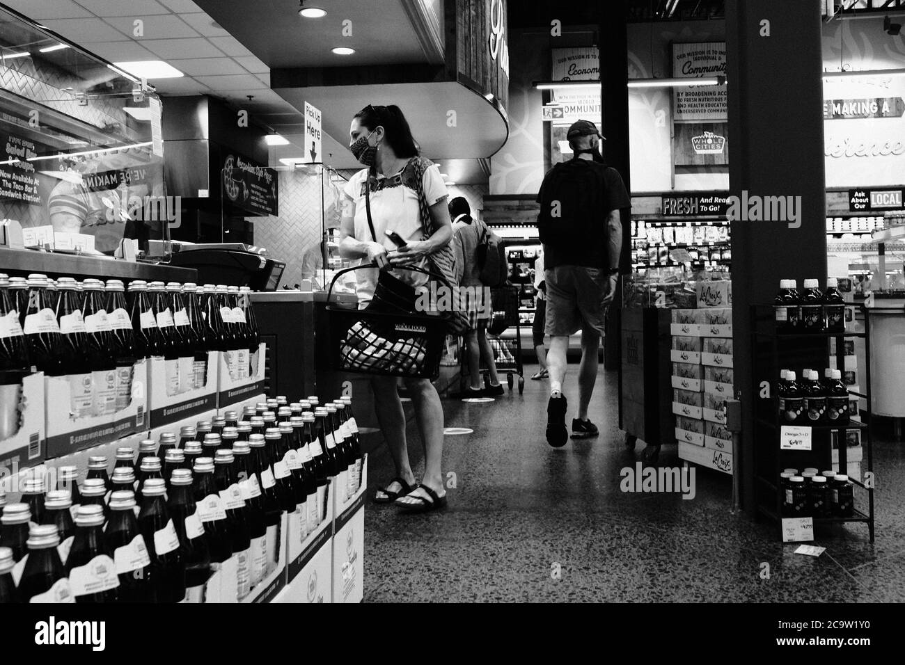 Foto in bianco e nero di maschera indossata, acquirenti socialmente distanziati nel negozio Whole Foods locale, Stage 3, Ottawa, Ontario, Canada. Foto Stock