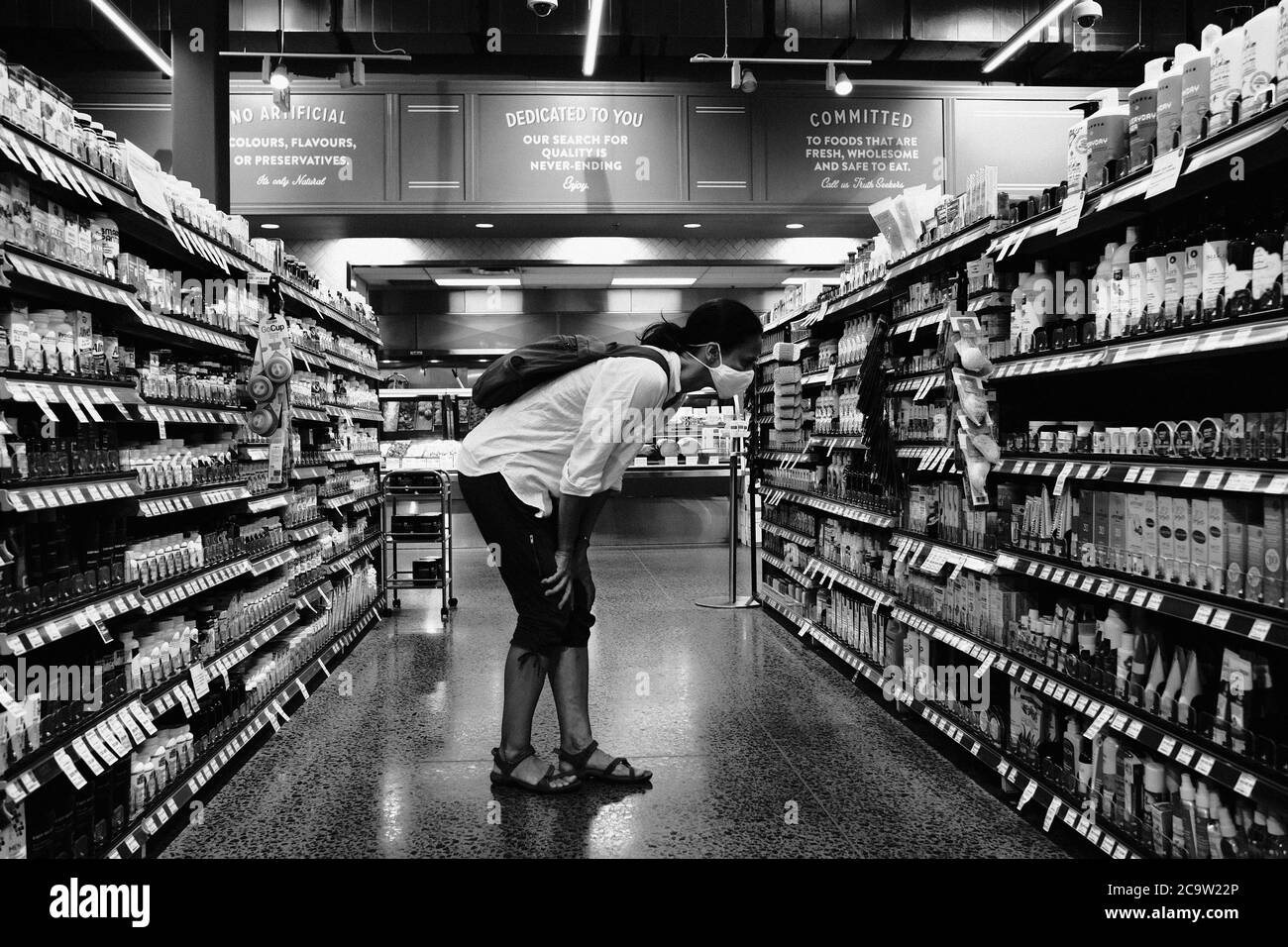 Foto in bianco e nero di maschera indossata, shopper socialmente distanziato nel negozio Whole Foods locale, fase 3 riapertura, Ottawa, Ontario, Canada. Foto Stock