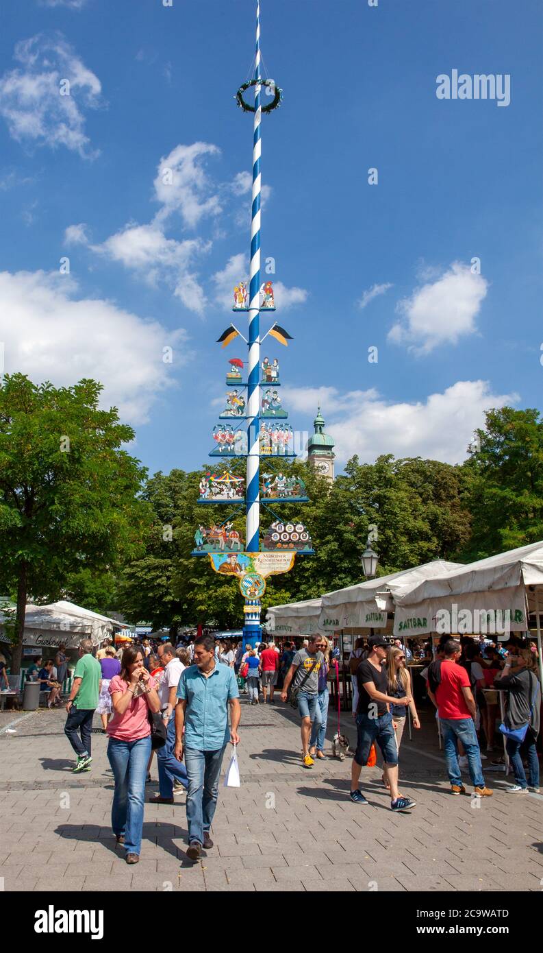 Maypole, Viktualienmarkt, Monaco, Baviera, Germania. Le figure rappresentano i vari prodotti alimentari disponibili in questo venerabile, gourmet, mercato all'aperto. Foto Stock