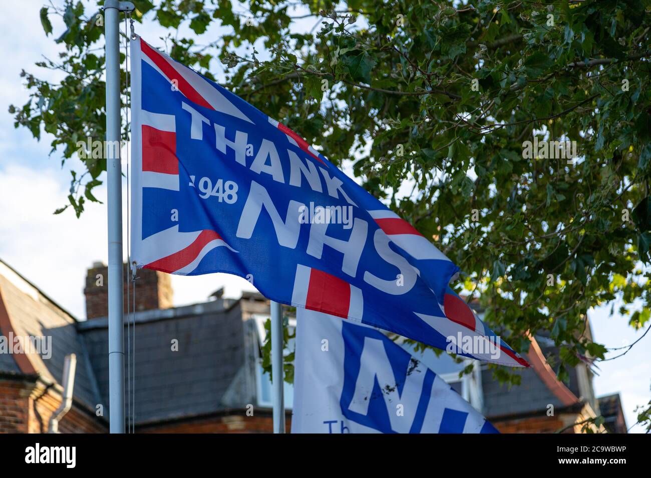 Bandiere su un palo di bandiera con le parole ringrazia NHS su di loro durante il coronavirus o Covid-19 pandemia Foto Stock
